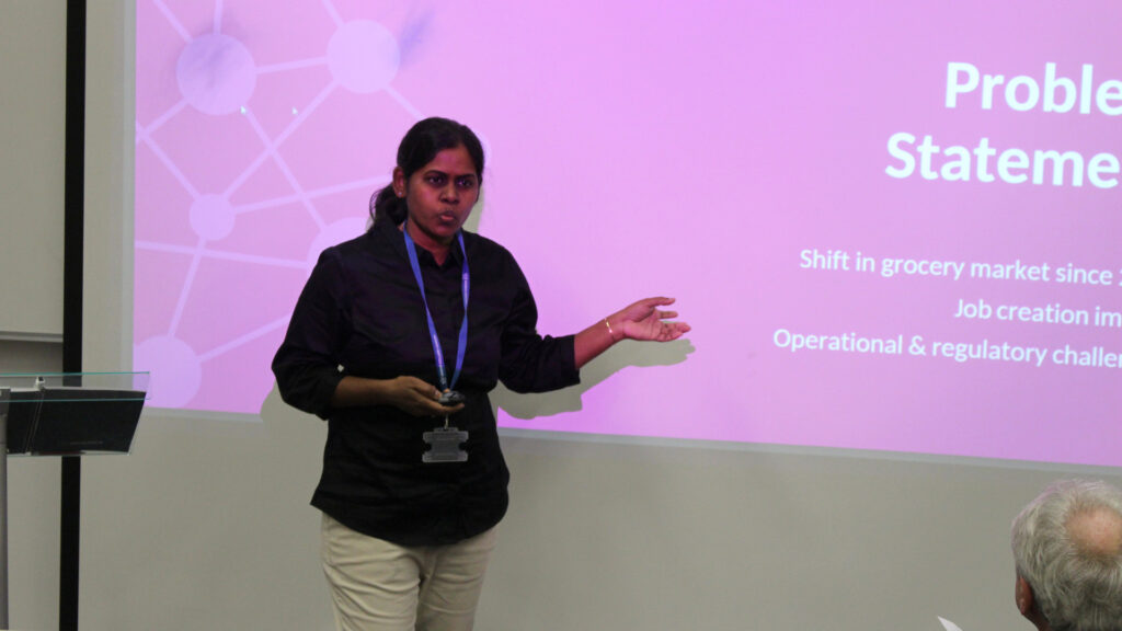 An RCL Business student delivering a presentation in an auditorium.