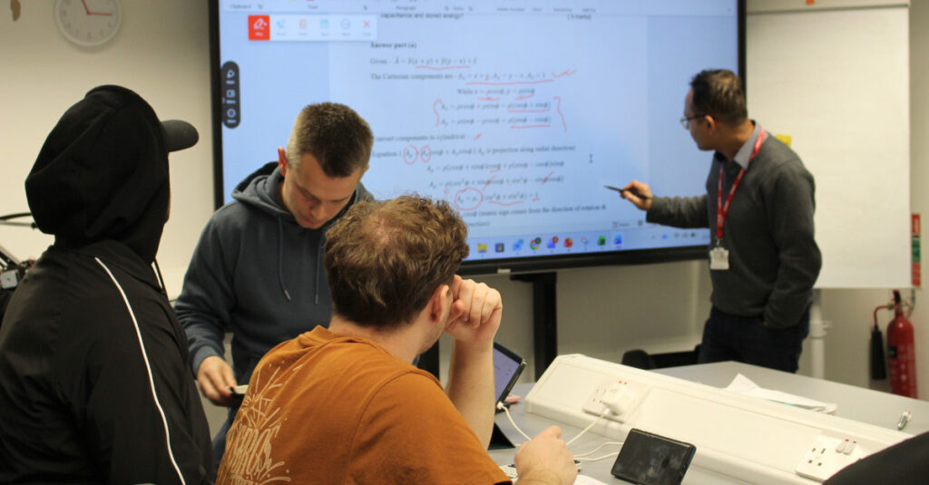 A group of RCL BSc students observe their tutor's lesson in an Engineering Lab.