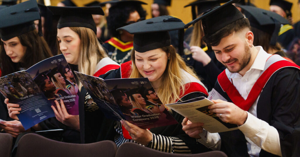 RCL graduates sit and read the Winter Graduation Ceremony 2026 booklet.