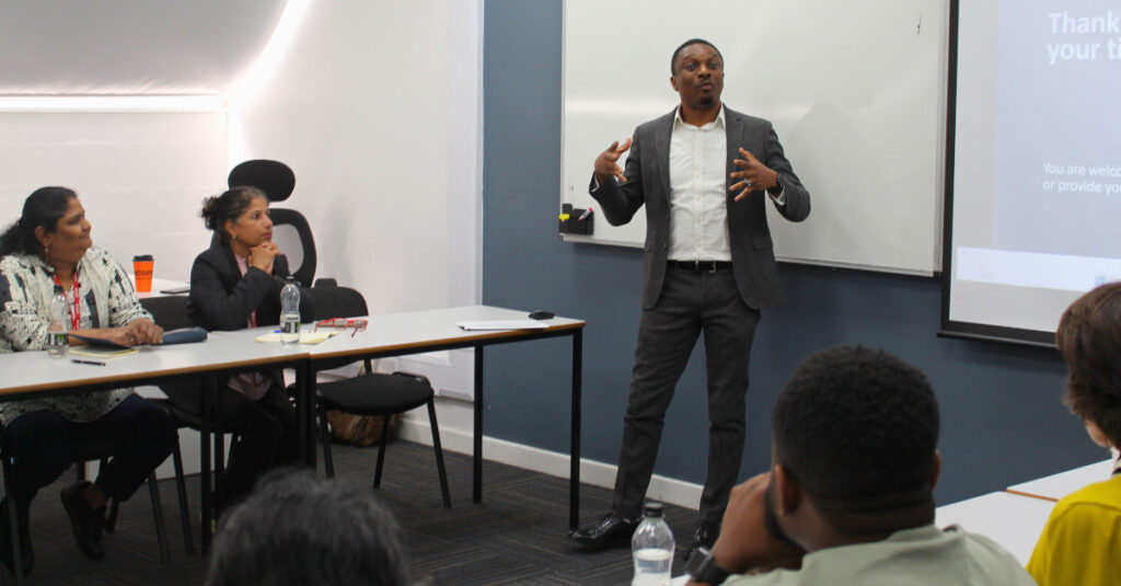 Kunle Adewole, an RCL academic, delivers a presentation in a classroom.